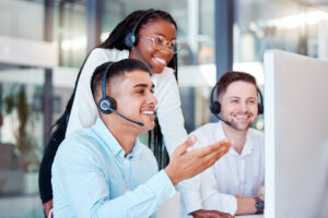 Telemarketing, training and black woman coaching team of men at customer service agency. Diversity, teamwork and crm, call center sales manager consulting staff at desk for customer support help line